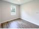 An empty bedroom offers wood look floors and a window overlooking the outdoors at 17381 Tyler Ave, Port Charlotte, FL 33948