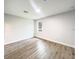 An empty bedroom offers wood look floors and a window overlooking the outdoors at 17381 Tyler Ave, Port Charlotte, FL 33948