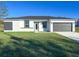 Beautiful single-story home with a well-manicured lawn and modern gray and white color scheme at 17381 Tyler Ave, Port Charlotte, FL 33948