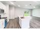 A gourmet kitchen features stainless appliances, a large island with sink, and wood look floors at 17381 Tyler Ave, Port Charlotte, FL 33948