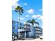 Beautiful exterior view of a blue condominium complex with palm trees and a covered entrance at 2700 Coconut Bay Ln # 419, Sarasota, FL 34237