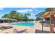 Community pool with lounge chairs and shady umbrellas surrounded by lush trees at 2700 Coconut Bay Ln # 419, Sarasota, FL 34237