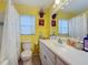 Bathroom featuring a white vanity, toilet and shower-tub combo with curtain at 1978 Radcliffe N Dr, Clearwater, FL 33763
