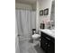 Well-lit bathroom with a vanity, toilet, and shower with a silver curtain, creating a clean space at 6315 Hillview Rd, Spring Hill, FL 34606