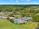 Aerial view showcasing a community pool, tennis courts, and lush landscaping at 9005 Players Dr, Weeki Wachee, FL 34613