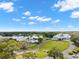 Gorgeous aerial view of a lush community with a lake, pool, clubhouse, and winding roads at 9275 Players Dr, Weeki Wachee, FL 34613