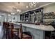 Stylish bar with a marble countertop, mosaic tile accents, ample liquor storage, and comfortable seating at 9275 Players Dr, Weeki Wachee, FL 34613