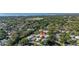 Scenic aerial view of a neighborhood surrounded by lush trees, with a glimpse of a waterway at 1103 Kensington Ct, Safety Harbor, FL 34695