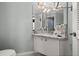 Well-lit bathroom featuring a granite vanity, large mirror, and coastal decor at 1103 Kensington Ct, Safety Harbor, FL 34695