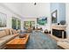 Bright living room with a vaulted ceiling, a fireplace, and sliding glass doors to the patio at 1103 Kensington Ct, Safety Harbor, FL 34695