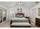 Comfortable main bedroom featuring a ceiling fan, wood furniture, and a sliding glass door to the outside at 1103 Kensington Ct, Safety Harbor, FL 34695