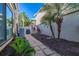 Neat side yard with a stone pathway, tropical landscaping, and well-maintained garden beds at 1103 Kensington Ct, Safety Harbor, FL 34695