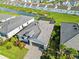 Aerial view of a home with a screened pool, manicured landscaping, and lake view at 11330 Burgundy Dr, Venice, FL 34293