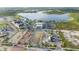 Aerial view of a commercial area with shops, parking, and a nearby lake and green space at 11330 Burgundy Dr, Venice, FL 34293