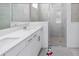 Modern bathroom featuring double sinks, white cabinets, and a glass-enclosed shower at 11330 Burgundy Dr, Venice, FL 34293