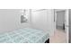 Neutral bedroom showcasing a bed with a teal and gray circular pattern quilt and a large closet at 11330 Burgundy Dr, Venice, FL 34293