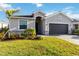 Inviting single-Gathering home featuring lush green grass, a paved driveway, and an attached two-car garage at 11330 Burgundy Dr, Venice, FL 34293