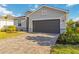 Charming single-Gathering home features a brick-paved driveway, gray siding, and well-manicured landscaping at 11330 Burgundy Dr, Venice, FL 34293