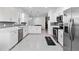 Contemporary kitchen featuring white cabinets, stainless steel appliances, and a stylish tile backsplash at 11330 Burgundy Dr, Venice, FL 34293