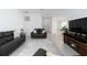 Comfortable living room featuring dark leather furniture and a view to the kitchen at 11330 Burgundy Dr, Venice, FL 34293