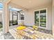 Outdoor patio with brick flooring, furniture, and views of screened enclosure and a well manicured lawn at 11330 Burgundy Dr, Venice, FL 34293