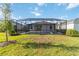 Inviting screened pool surrounded by a lush green lawn and manicured landscaping at 11330 Burgundy Dr, Venice, FL 34293