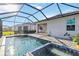 Screened pool with spa, brick flooring, and views of home, lawn and well manicured landscaping at 11330 Burgundy Dr, Venice, FL 34293