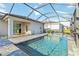 Screened pool with spa, brick flooring, and views of home, lawn and well manicured landscaping at 11330 Burgundy Dr, Venice, FL 34293