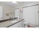 Bathroom featuring gray countertops, white cabinets, and a shower with a curtain, creating a clean space at 6288 Winding Pine Dr, Nokomis, FL 34275