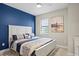 Cozy bedroom with a white wood-frame bed, blue accent wall, and neutral-toned decor at 6288 Winding Pine Dr, Nokomis, FL 34275