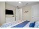This bedroom features neutral walls, a sleek white dresser with a TV, and a coastal-themed fish decoration on the wall at 6288 Winding Pine Dr, Nokomis, FL 34275