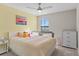 Bright bedroom featuring a cheerful flamingo painting, a comfortable bed, and a white dresser for storage at 6288 Winding Pine Dr, Nokomis, FL 34275