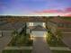 Charming two-story home with landscaped yard and paver driveway set against a colorful sunset backdrop at 6288 Winding Pine Dr, Nokomis, FL 34275