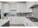 Modern kitchen with white cabinets, gray backsplash, and stainless steel appliances at 6288 Winding Pine Dr, Nokomis, FL 34275