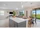 Open-concept kitchen island with seating, connecting seamlessly to the dining and living areas at 6288 Winding Pine Dr, Nokomis, FL 34275