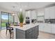 Stylish kitchen island with seating, pendant lighting, and view to outdoor patio and backyard at 6288 Winding Pine Dr, Nokomis, FL 34275