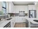Well-appointed kitchen with white cabinetry, stylish backsplash, and stainless steel appliances at 6288 Winding Pine Dr, Nokomis, FL 34275