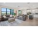 Spacious living room with comfortable seating, large windows, and an open layout connecting to the kitchen area at 6288 Winding Pine Dr, Nokomis, FL 34275