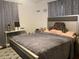 Cozy bedroom featuring a plush bed with decorative pillows and patterned gray curtains at 12322 Alta Mira St, North Port, FL 34287