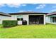 Rear exterior view of the property highlighting a screened-in lanai and well-maintained lawn at 19165 Iron Topsail Isle, Land O Lakes, FL 34638