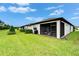 This backyard features well maintained lawn, landscaping and a screened-in patio with outdoor furniture at 19165 Iron Topsail Isle, Land O Lakes, FL 34638