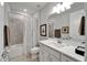 Bright bathroom with white vanity, tiled shower-tub, and decorative framed artwork at 19165 Iron Topsail Isle, Land O Lakes, FL 34638