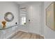 Bright entryway with wood-look flooring, glass table and accent mirror at 19165 Iron Topsail Isle, Land O Lakes, FL 34638