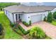 Well-manicured landscaping enhances this charming one-story home with a brick paver driveway at 19165 Iron Topsail Isle, Land O Lakes, FL 34638