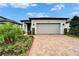 Lovely front exterior displaying brick driveway, blue front door with wreath, and green landscaping at 19165 Iron Topsail Isle, Land O Lakes, FL 34638