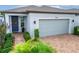 Close-up of home's front exterior showcasing brick paved driveway, covered entryway, and two-car garage at 19165 Iron Topsail Isle, Land O Lakes, FL 34638