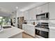 Contemporary kitchen featuring stainless steel appliances and a light gray backsplash and white cabinetry at 19165 Iron Topsail Isle, Land O Lakes, FL 34638