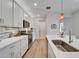 Modern kitchen with white cabinets, stainless appliances, and light wood-look floors at 19165 Iron Topsail Isle, Land O Lakes, FL 34638