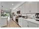 Bright, open kitchen with stainless steel appliances, quartz counters, and light wood-look floors at 19165 Iron Topsail Isle, Land O Lakes, FL 34638