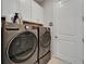 Modern laundry room featuring a gray LG washer and dryer set with storage cabinets above at 19165 Iron Topsail Isle, Land O Lakes, FL 34638